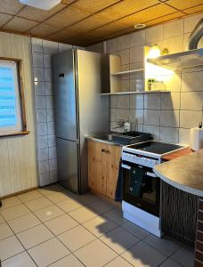 a kitchen with a stainless steel refrigerator and a stove at Domek letniskowy Podamirowo in Podamirowo +7 photos