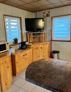 a living room with a flat screen tv and a table at Domek letniskowy Podamirowo in Podamirowo
