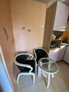 a room with two chairs and a glass table at The Flamingo 2 in Jos +2 photos