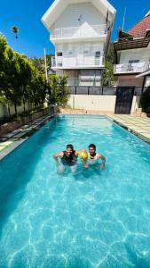 two men are swimming in a swimming pool at Casavalley in Anachal