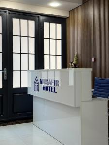 a lobby with a miskar hotel sign on a reception desk at Musafir Hotel in Tashkent
