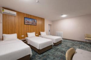 a hotel room with two beds and a wall at Musafir Hotel in Tashkent +77 photos