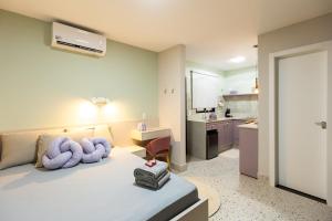 a bedroom with a bed with purple towels on it at 105-Apto Confortável com Ar Próximo à UEL in Londrina