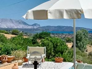 a white umbrella sitting on top of a patio at Li Muntigeddi in San Teodoro