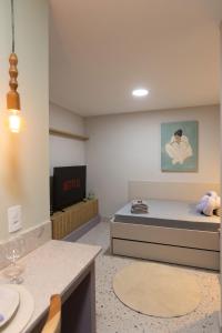 a small room with a bed and a tv at 105-Apto Confortável com Ar Próximo à UEL in Londrina