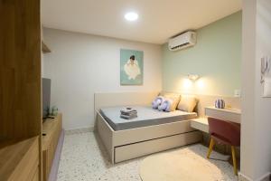 a small room with a bed and a desk at 105-Apto Confortável com Ar Próximo à UEL in Londrina