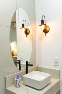 a bathroom with a sink and a mirror at 105-Apto Confortável com Ar Próximo à UEL in Londrina +43 photos