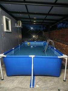 een groot blauw zwembad in een garage 's nachts bij Homestay Ummi Baling in Baling