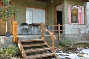 a house with a wooden staircase in front of it at Girgola hospedaje in Villa Pehuenia