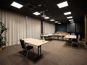 une salle de conférence avec des tables et des chaises dans l'établissement Ibis Poznan Polnoc, à Suchy Las