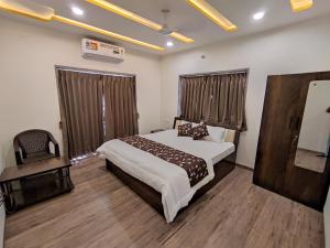 a hotel room with a bed and a chair at RT RESIDENCY HOTEL and LODGE in Nandurbār