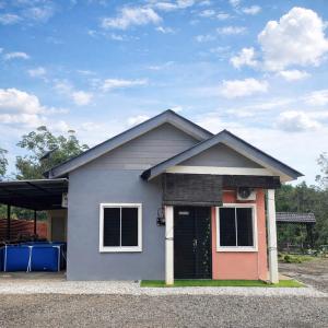 een klein huis met een deur in een oprit bij Homestay Ummi Baling in Baling +9 foto's