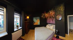 une chambre avec un lit blanc dans un mur noir dans l'établissement Ferienhaus An der Burg, à Oschersleben