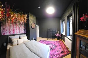 une chambre avec un lit blanc et un tapis rose dans l'établissement Ferienhaus An der Burg, à Oschersleben