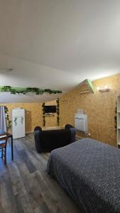 una camera da letto con un letto e un divano in una stanza di studio 4 a Fains-les-Sources 1 altra foto