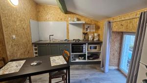 una piccola cucina con un tavolo e un lavandino di studio 4 a Fains-les-Sources
