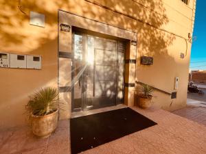 a door to a building with two potted plants at ZyonFamily in Ouarzazate