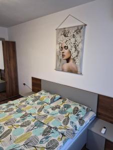 een bed in een slaapkamer met een foto aan de muur bij Апартаменти Арт in Stara Zagora
