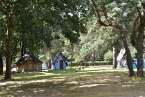 een groep hutten in een park met bomen bij camping de brocéliande in Néant-sur-Yvel +10 foto's