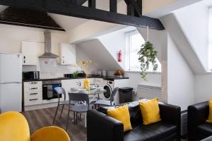 eine Küche und ein Wohnzimmer mit Sofa und Tisch in der Unterkunft The residency appartment's in Litherland