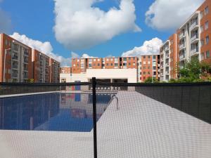 een zwembad met gebouwen op de achtergrond bij Apartamento en Ibagué Campestre in Ibagué