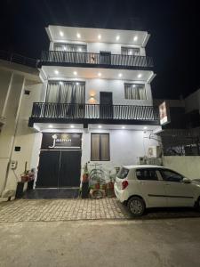 a white car parked in front of a house at Jasmin A Luxury Stay-900m Walk To The Taj Mahal,Free Parking in Agra