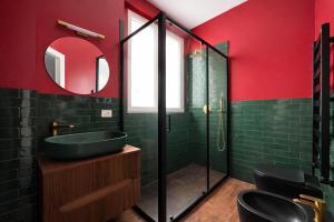 un bagno con un lavandino verde e uno specchio di Maison Gucci a Milano