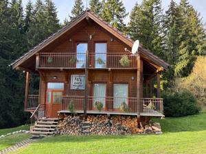a log cabin with a porch and a balcony at Chata pri lese,Liptov in Bobrovec