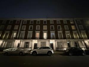 two cars parked in front of a large building at night at Fantastic Two Bed Flat In Paddington Central London Zone 1 in London