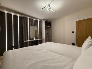 a bedroom with a white bed with a ceiling fan at Fantastic Two Bed Flat In Paddington Central London Zone 1 in London