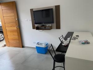 una cucina con tavolo e TV a parete di Casa da Praia Edmara a Guaratuba