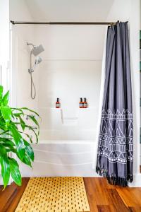 - un rideau de douche dans la salle de bains pourvue d'une plante dans l'établissement Jungle House Chillicothe - Luxury Downtown Homes Free Parking, à Chillicothe