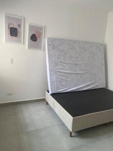 un letto in una camera con due immagini sul muro di Casa da Praia Edmara a Guaratuba