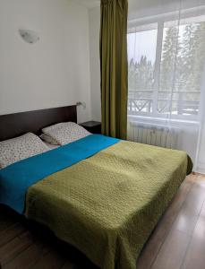 een bed in een kamer met een raam en een bed sidx sidx sidx bij STRIM Apartment 406 Stream Resort, Pamporovo in Pamporovo +35 foto's