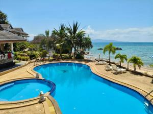 a swimming pool with the ocean in the background at Phangan Orchid Resort in Ban Tai