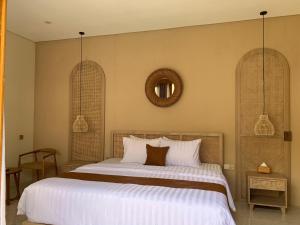 a bedroom with a large bed and two windows at Kamaya Villa Jogja in Ngaglik +9 photos