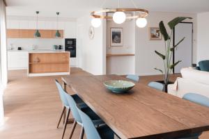 a dining room and kitchen with a wooden table and chairs at Conserveira 8 in Olhão