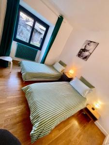 deux lits dans une chambre avec fenêtre dans l'établissement Château du Vigny - Gîte, à Saint-Michel-de-Maurienne