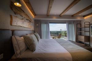 a bedroom with a bed and a large window at Casa Pradera - Hotel Serrano in Sierra de los Padres