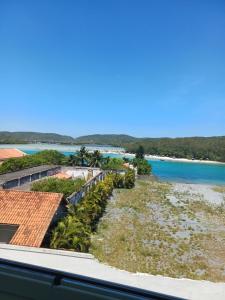 uitzicht op het strand vanaf het balkon van een resort bij Residencial pacific in Cabo Frio