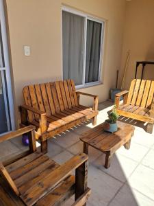 twee houten stoelen en een tafel in een kamer bij Departamentos Los corrales in San Andrés de Giles