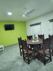 een eetkamer met een tafel en stoelen en een flatscreen-tv bij Departamentos Los corrales in San Andrés de Giles