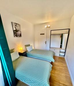 deux lits côte à côte dans une pièce dans l'établissement Château du Vigny - Gîte, à Saint-Michel-de-Maurienne