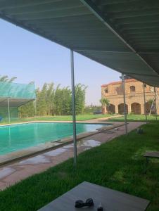 een paar schoenen die onder een tent bij een zwembad staan bij Ferme d'hôtes Safi in Safi