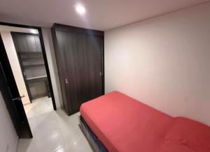 ein kleines Zimmer mit einem roten Bett und einer Tür in der Unterkunft Departamento en Arequipa in Arequipa