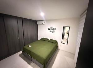 ein Schlafzimmer mit einem grünen Bett in einem Zimmer in der Unterkunft Departamento en Arequipa in Arequipa