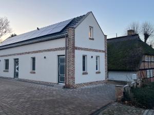 een wit huis met een dak met zonnepanelen erop bij Haus Maria am Meer in Göhren