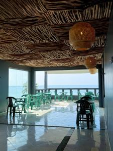 a room with chairs and tables and a view of the ocean at Moringa Beach in Mirissa