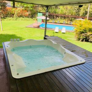 een hot tub op een terras naast een zwembad bij SUITES - Românticas na natureza para adultos in Itapecerica da Serra