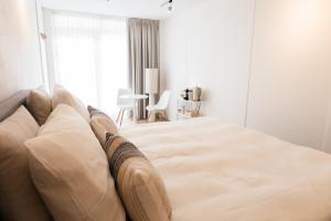 a white bedroom with a large bed in front of a window at B&B s12 in Doetinchem